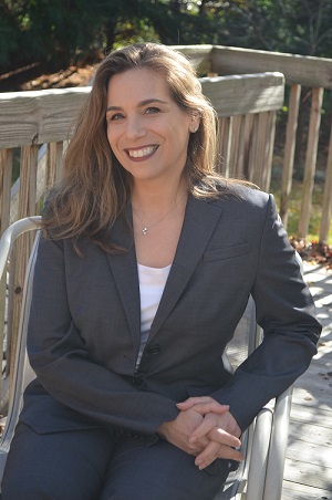 white woman in a gray suit sitting outside